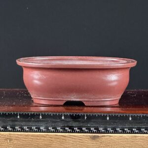 Red ceramic bowl with a ruler.