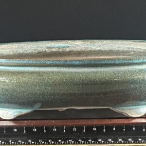 Blue ceramic bowl on wooden stand.