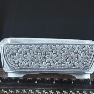 Decorative floral-patterned ceramic planter with ruler.