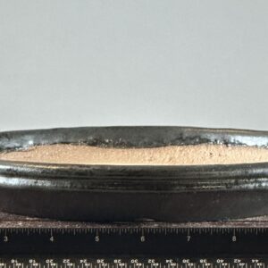 Black ceramic bowl with granular contents.
