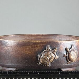 Brown pottery bowl with turtle designs.