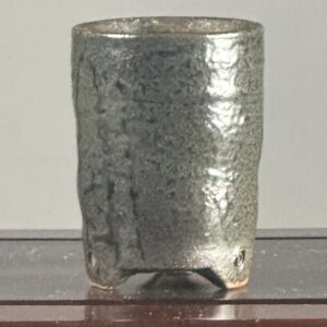 Textured ceramic cup on a wooden surface.