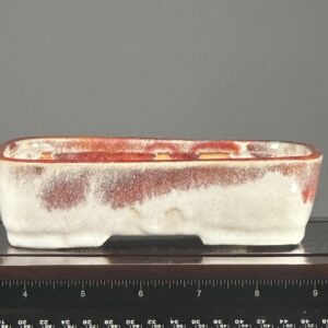 Rectangular ceramic pot with red and white.