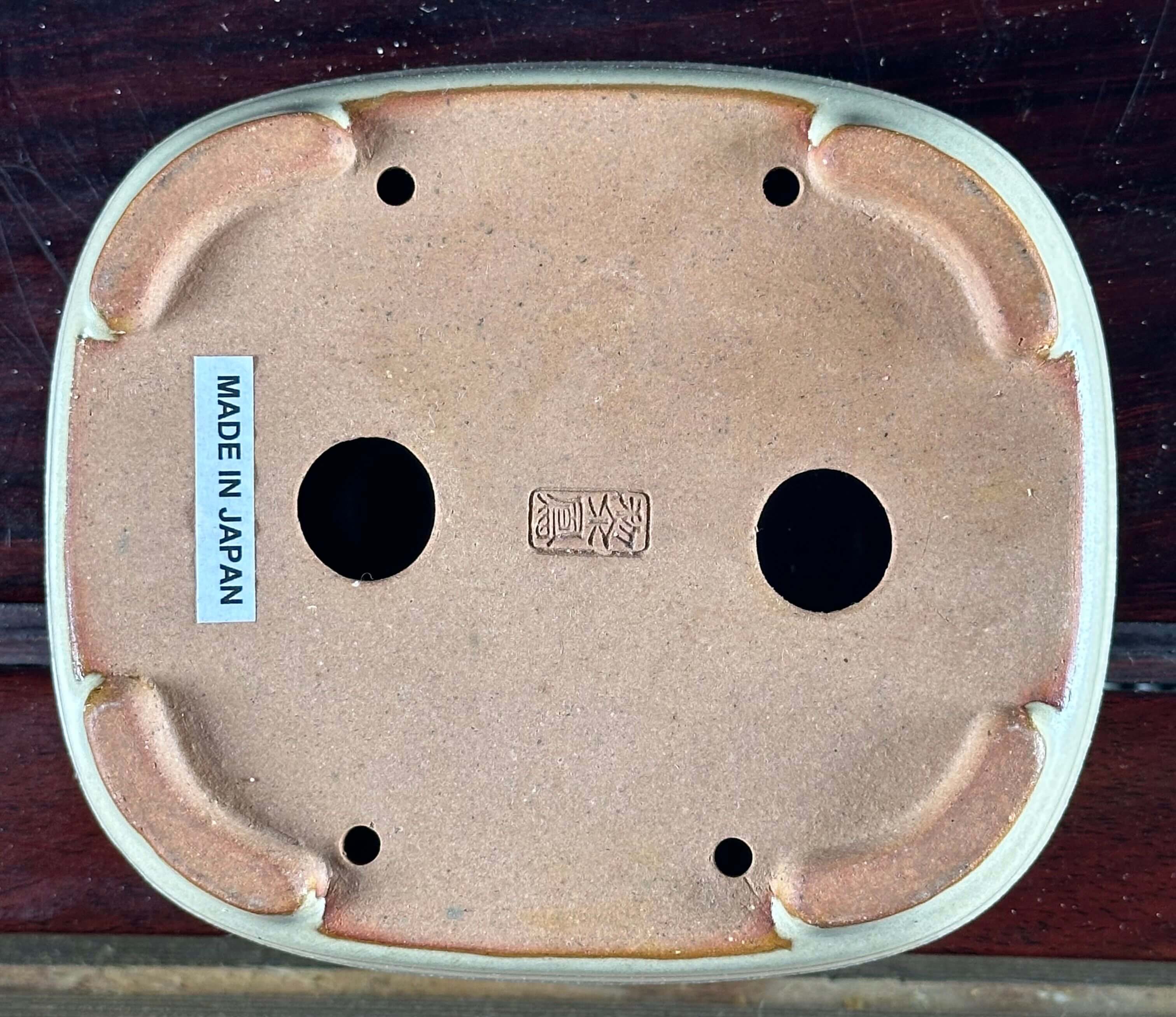 Underside of Japanese pottery with label.