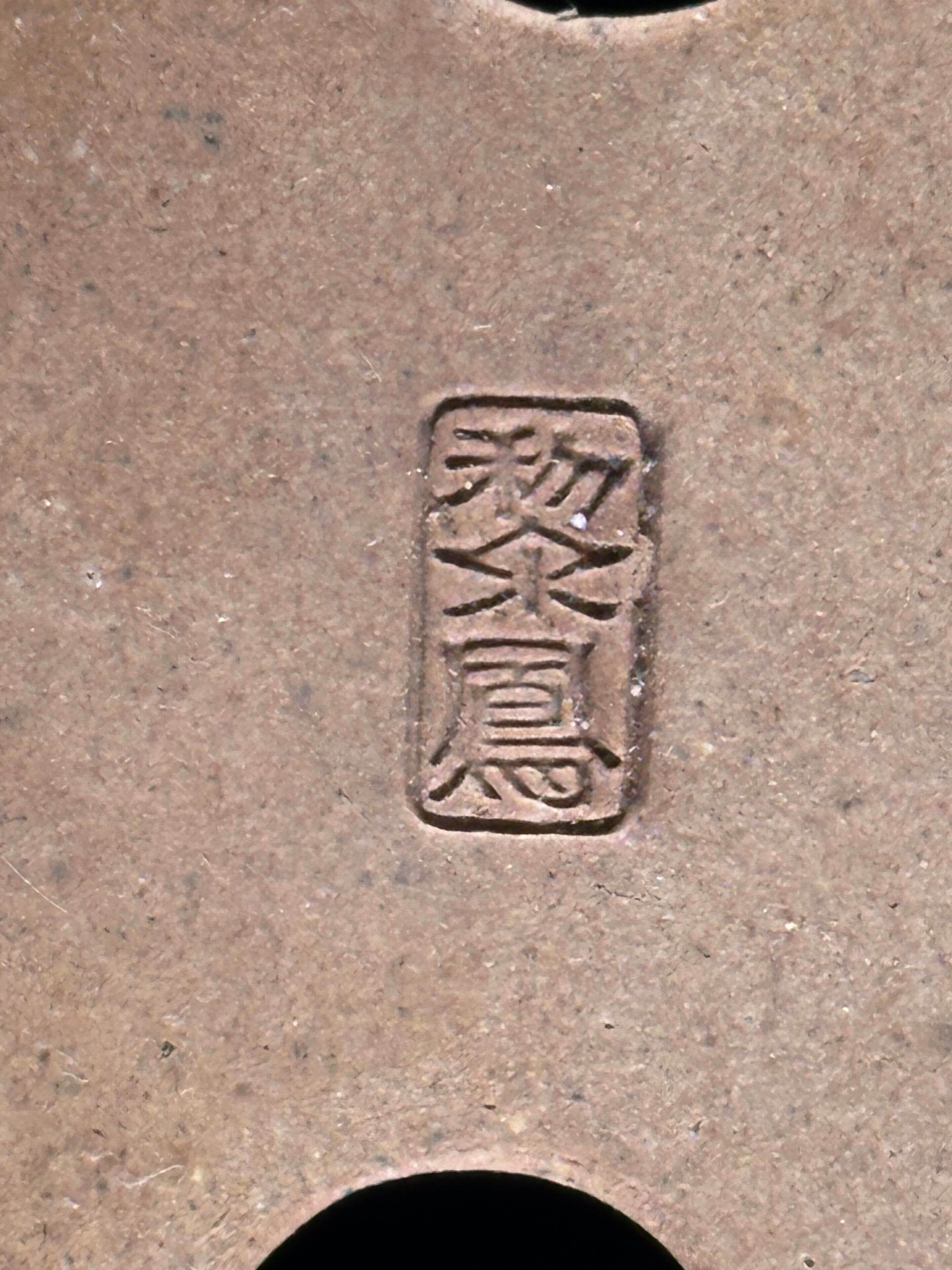 Chinese characters engraved on brown surface.