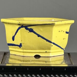 Yellow ceramic pot with blue splatter design.