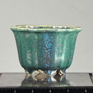 Green ceramic pot with textured surface.